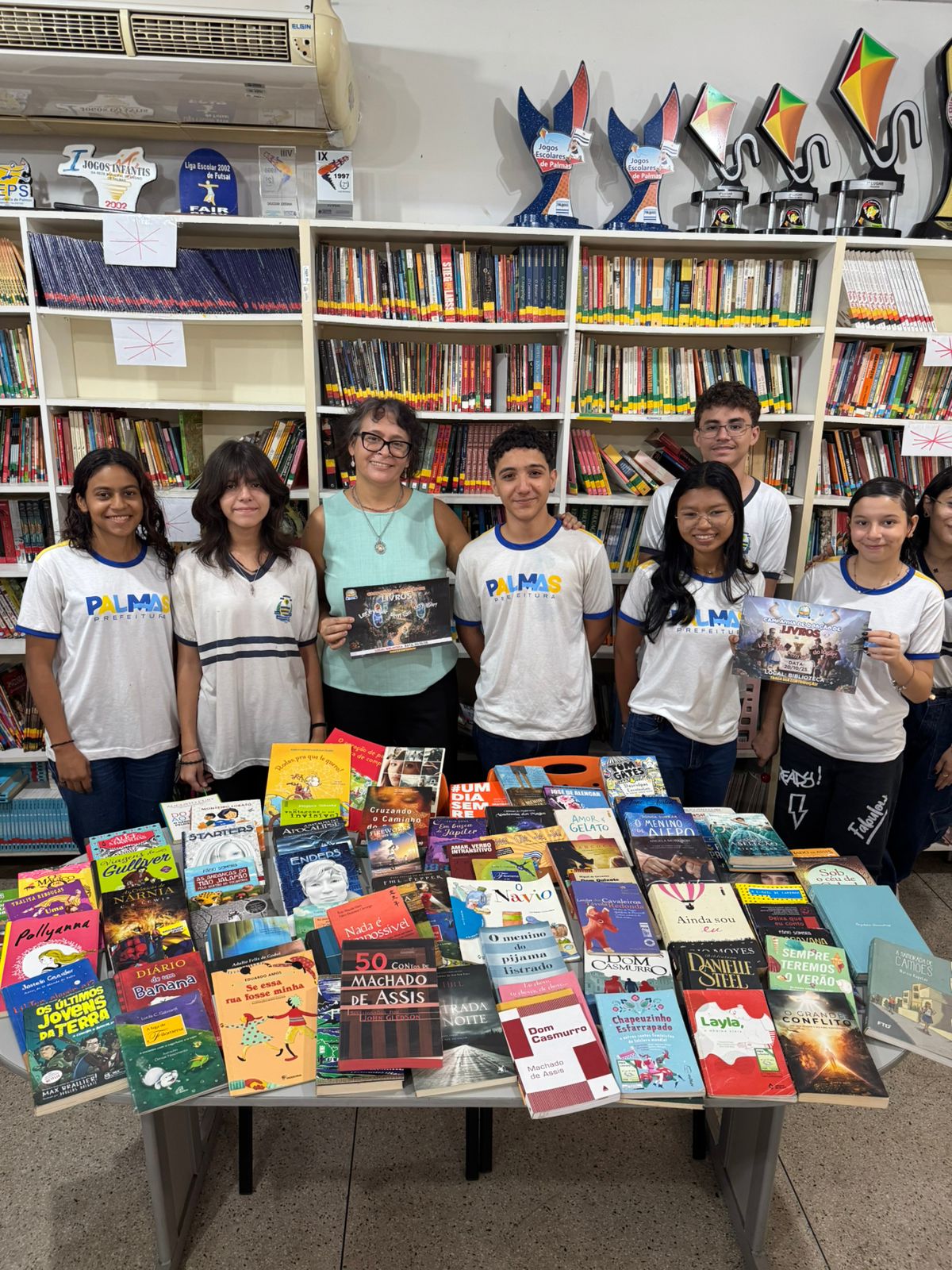 Professora Roseli, alunos leitores e parte das doações já recebidas: biblioteca atraente aos alunos da escola Darcy Ribeiro